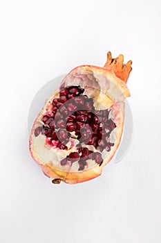 Isolated part of a grenade on a white background close-up view from above. Fresh pomegranate. Juicy Delicious