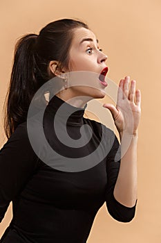 Isolated on pastel young casual woman shouting at studio