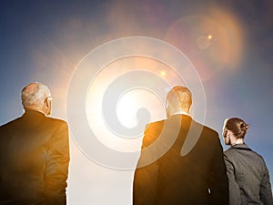 Isolated photo of Rear view of three business people looking at sun
