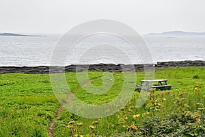 Isolated picnic table on ocean shoreline. Abandoned wood picnic table