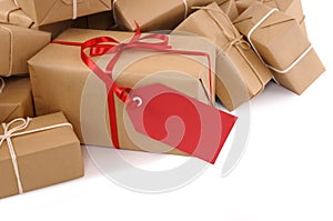 Isolated pile of brown packages, red gift label, copy space