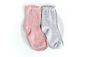 Isolated pink and gray baby socks on a white
