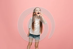 Isolated on pink young casual teen girl shouting at studio