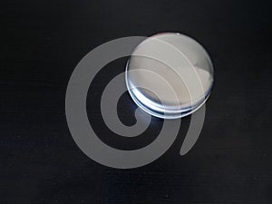 Isolated Plain round tin cannister on a dark background holding unknown contents version 1