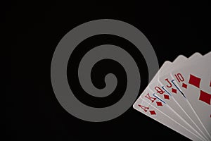 Isolated playing cards with royal flush of diamonds poker combination on the black background. Copy space