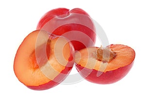 Isolated plums. One and a half of red plum fruit with leaves isolated on white background.