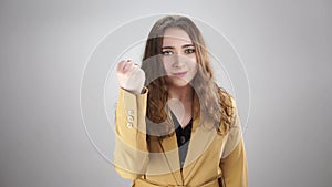 Isolated portrait of an angry woman threatening by showing fist on a white background