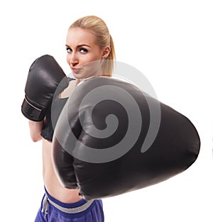 Isolated portrait of athletic Asian woman in black boxing gloves. Slim athletic girl in training clothes looking at