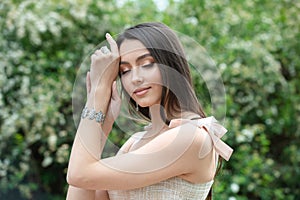 Isolated portrait of beautiful brunette woman with straight hair and elegant makeup on nature background