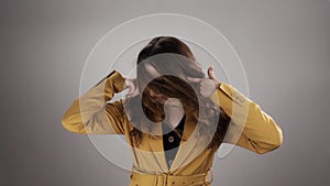 Isolated portrait of woman closing ears by fingers and waving head in slow motion
