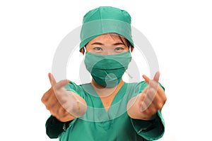 Isolated portrait of young beautiful and happy Asian Korean medicine doctor woman or hospital nurse in medical hat mask and scrub
