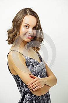 Isolated portrait of young and charming woman hugging herself, wearing summer shirt, has a stylish short hairstyle, has