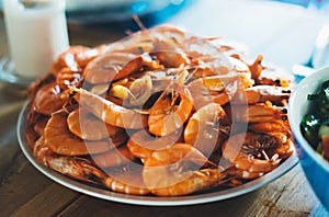 Isolated prepared orange shrimp on background table on home kitchen, closeup of fresh prawn products, shellfish sea food on plate