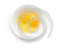 Isolated raw chicken eggs, top view of two raw egg yolk in white bowl on white background