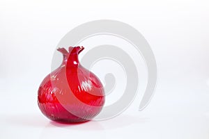 Isolated red, pomegranate shaped glass object with white background. photo