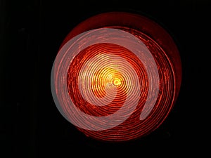 Isolated red street traffic light closeup with yellow undertone photo