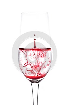 isolated of red water drop to wine glass is still on white background