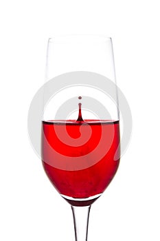 isolated of red water drop to wine glass is still on white background