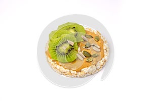 Isolated rice cake with peanut butter with slice of kiwi and seeds on white background