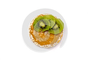 Isolated rice cake with peanut butter with slice of kiwi on white background