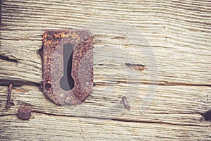 Isolated rusty keyhole on old wooden door