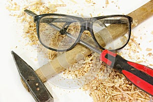 Isolated safety glasses, hammer and screwdriver on