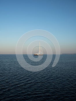 Isolated sailing boat ship yacht on deep blue open water mediterranean sea ocean Mallorca Balearic Islands Spain