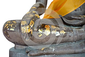 Isolated selective focus on closeup hand of buddha statue coated by the golden leaf on white background