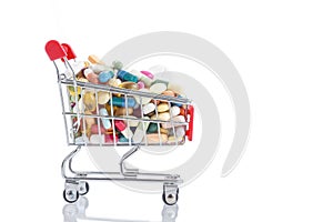Isolated shopping cart full of medicine with pills and capsules