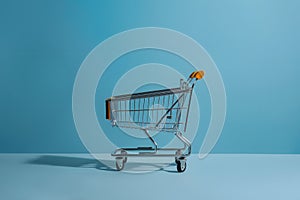 Isolated shopping trolley against calming blue background, minimalist vibe