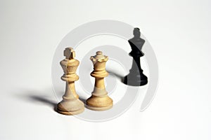 Isolated shot of two white and one black chess figures on a white background