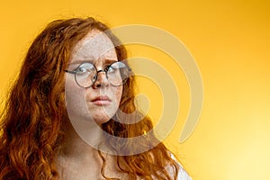 Isolated shot of young funny redhead female stares at camera with shoked expression photo
