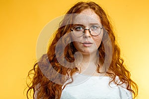 Isolated shot of young funny redhead female stares at camera with shoked expression photo