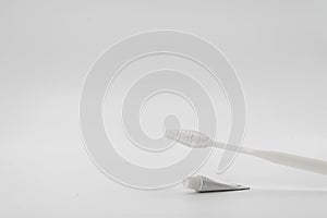Isolated simple and normal white toothbrush with small toothpaste on the white background in studio light