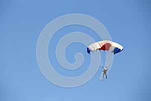 Isolated skydiver control colorful parachute gliding after free