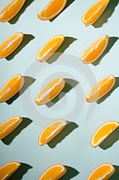 Isolated slices of orange on a light blue background.