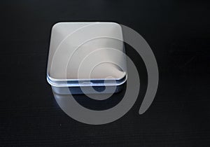 Isolated Plain rectangular tin cannister on a dark background holding unknown contents version 1