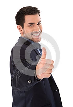Isolated smiling businessman making thumbs up gesture.