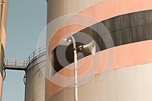 Isolated speaker near some oil storage tanks