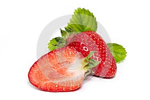 Isolated strawberries. Three fruits, one cut in half on white background