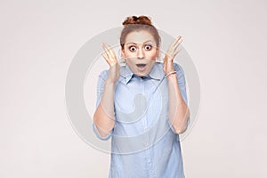 Isolated studio shot on gray background of happy successful young adult redhead woman, feeling lucky, looking