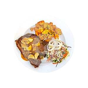 Isolated succulent steak with garlic gravy, spiced potatoes, and fresh salad on a white plate