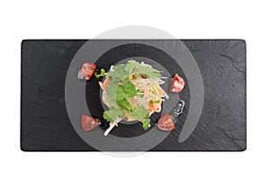 Isolated Too view of Diced salmon salad with avocado, tomato, onion, chilli, and coriander served in black rectangle stone plate.