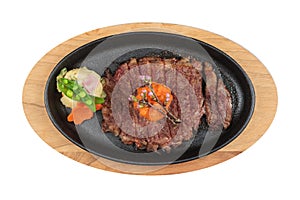 Isolated top view of medium rare wagyu steak topping with mince carrot on hot plate wooden plate served with potato salad.