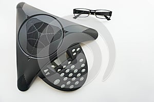 Isolated top view of voip IP conference phone with eye glasses on meeting room