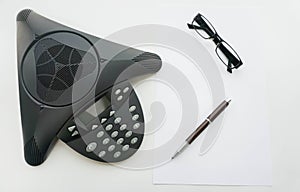 Isolated top view of Voip IP conference phone with glasses and pen