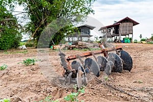 An isolated tractor disc plough is left unused.