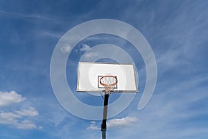 Isolated view of a basketball hoop and backboard under an expressive blue sky photo