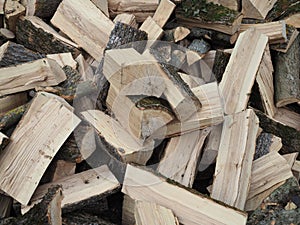 Isolated view on chopped wood. Piled in an unsorted way, looking quite chaotic. Ready to be set on fire