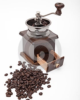 Isolated vintage coffee bean grinder and fresh ground coffee